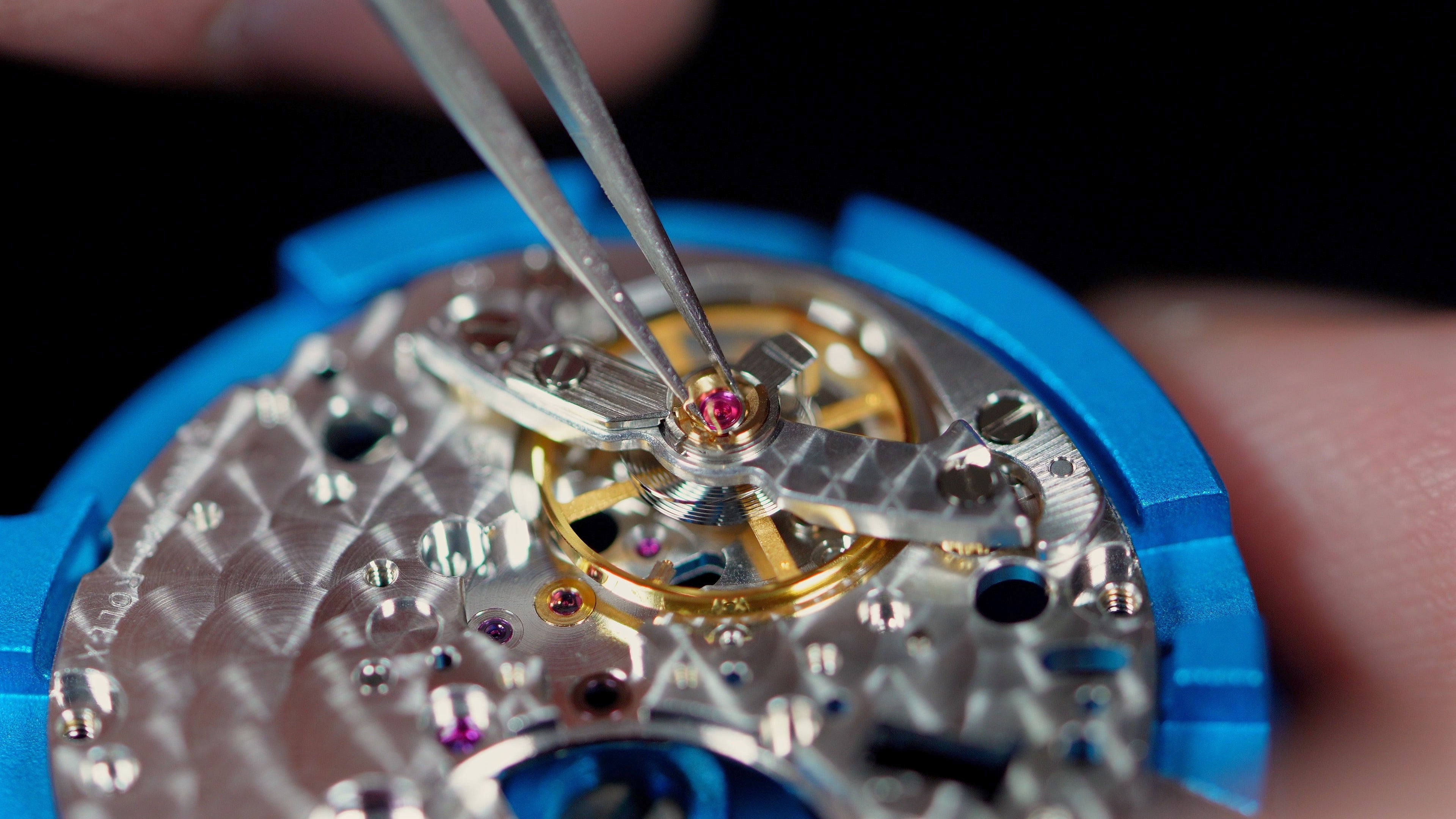 Gros plan sur le mécanisme d’une montre mécanique lors d’une restauration ou révision horlogère