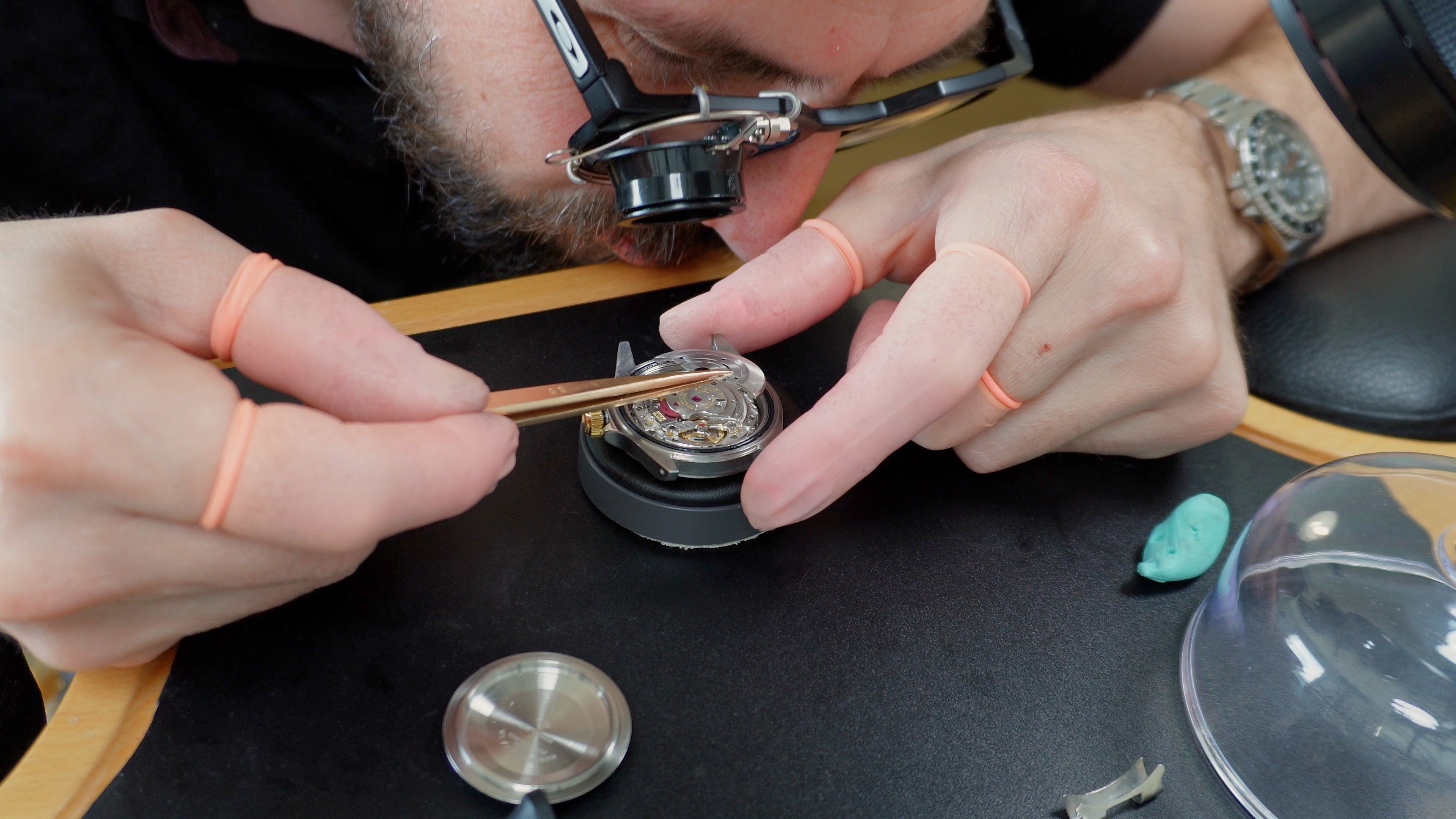 Horloger en pleine restauration d’une montre automatique démontée, réparation et révision du mouvement
